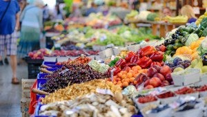 An image of a grocery store shelf with fruits and vegetables.