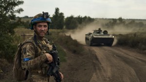 A Ukrainian soldier stands beside a road near Bakhmut