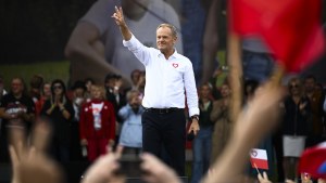 Opposition leader Donald Tusk, center, flashes a victory sign as he speaks.