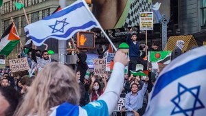 Israel supporters hold up flags as they demonstrate across 42nd Street from Palestinian supporters