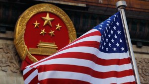 An American flag is flown next to the Chinese national emblem outside the Great Hall of the People in Beijing