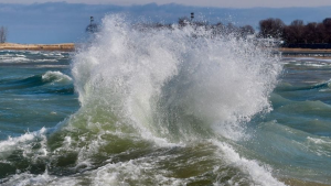 A strong wave hits along the shore of Lake Michigan