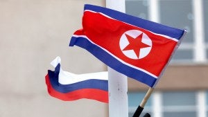 Flags of Russia and North Korea are seen along the road on Russky Island