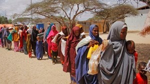 Somalis who fled amid drought carry their belongings as they arrive at a makeshift camp