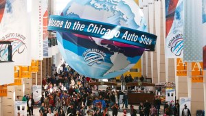 The entrance of the Chicago Auto Show with a large globe hanging over the crowd.
