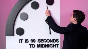 A person with a clock and the words "it is 90 seconds to midnight"