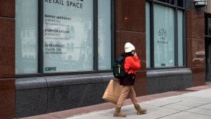 A person walks past an empty storefront