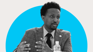 Black and white image of a person talking with a blue circle in the background