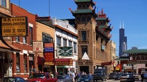 Signs above restaurants along a street, many in Chinese