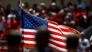 a crowd stands for the national anthem