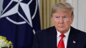 Donald Trump pictured in front of a NATO flag