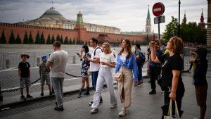 People walk along closed empty Red Square with the Kremlin Wall