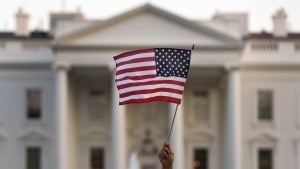 An American flag is waved outside the White House