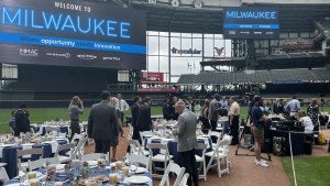 People set up a seated event in a baseball stadium