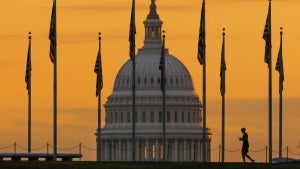 the silhouette of a person walking near the US Capitol