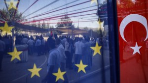 People are seen behind a European Union and a Turkish flag