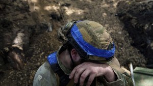 A Ukrainian national guard serviceman prepares to reload while firing towards Russian positions