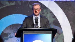 Dan Lynch speaks into a microphone onstage at the Global Leadership Awards Dinner.