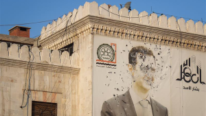 An image of Syrian President Bashar Assad, riddled with bullets, on the facade of the provincial government office in Hama, Syria.