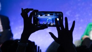 Person taking photo of Council stage with cell phone