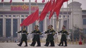 Chinese soldiers march to their post outside the Great Hall of the People in Beijing