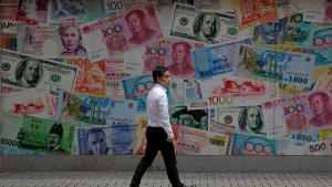 A man walks past a money exchange shop decorated with different banknotes in Hong Kong on September 25, 2019.