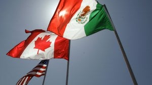 National flags representing the United States, Canada, and Mexico fly in the breeze