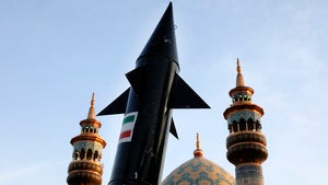 A model of a missile is carried by Iranian demonstrators as minarets and dome of a mosque is seen at background 