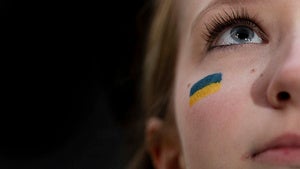 A Ukrainian flag is painted on a demonstrator's face during a rally in Times Square