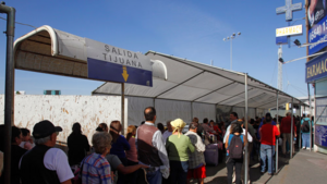 People wait in line at the US-Mexico border. 