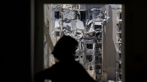 A police officer inspects a damaged apartment a day after a direct missile strike from Iran hit a residential building in Beersheba, Israel on June 25, 2025.