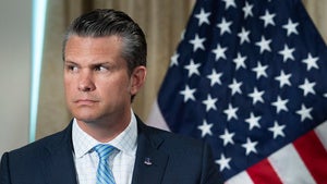 Secretary of Defense Pete Hegseth in front of an American flag