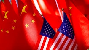 Two miniature American flags rest in front of a larger group of Chinese flags.