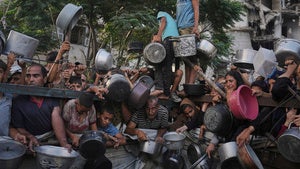alestinians struggle to get donated food at a community kitchen in Gaza City