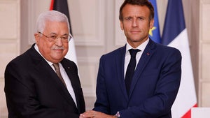 Palestinian President Mahmoud Abbas shakes hands with French President Emmanuel Macron