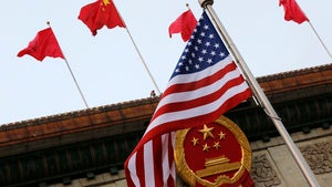 An American flag is flown next to the Chinese national emblem and flags