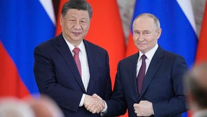 Russian President Vladimir Putin and Chinese President Xi Jinpin shake hands at the Kremlin