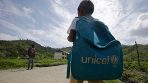 A student walks to school with a UNICEF backpack