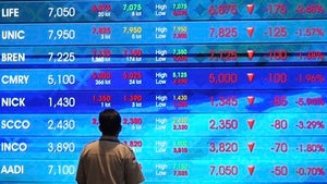 A man watches stock prices displayed on an electronic board at the Indonesia Stock Exchange in Jakarta, Indonesia on August 7, 2025.