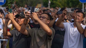 People use smartphones to film planes fly in formation during a military parade to commemorate the 80th anniversary of the end of World War II in Beijing