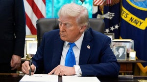 President Donald Trump signs an executive order in the Oval Office