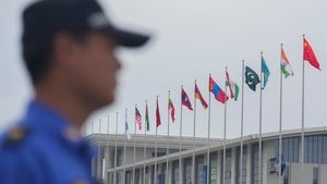 A security guard stands near the flags of Shanghai Cooperation Organization member states outside the venue in Tianjin, China on August 30, 2025.