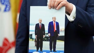 President Donald Trump holds a photo of himself with Russian President Vladimir Putin during an announcement in the Oval Office of the White House, Friday, Aug. 22, 2025, in Washington.