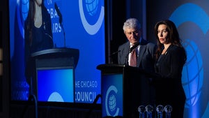 Two people speak while standing behind a podium