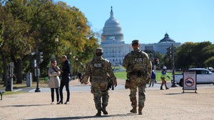 National Guard soldiers walking in front of capital building, adjacent to civilians