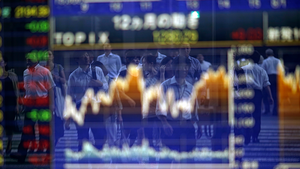 Pedestrians are reflected on an electronic stock board of a securities firm in Tokyo.