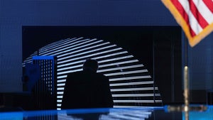 Donald Trump exits a stage under an American flag