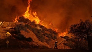 A firefighter battles the Palisades Fire in Mandeville Canyon
