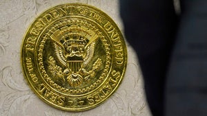A gold presidential seal in the Oval Office