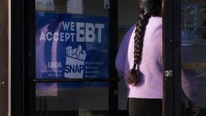 A customer walks into a bakery as a SNAP EBT information sign is displayed at the front door in Chicago